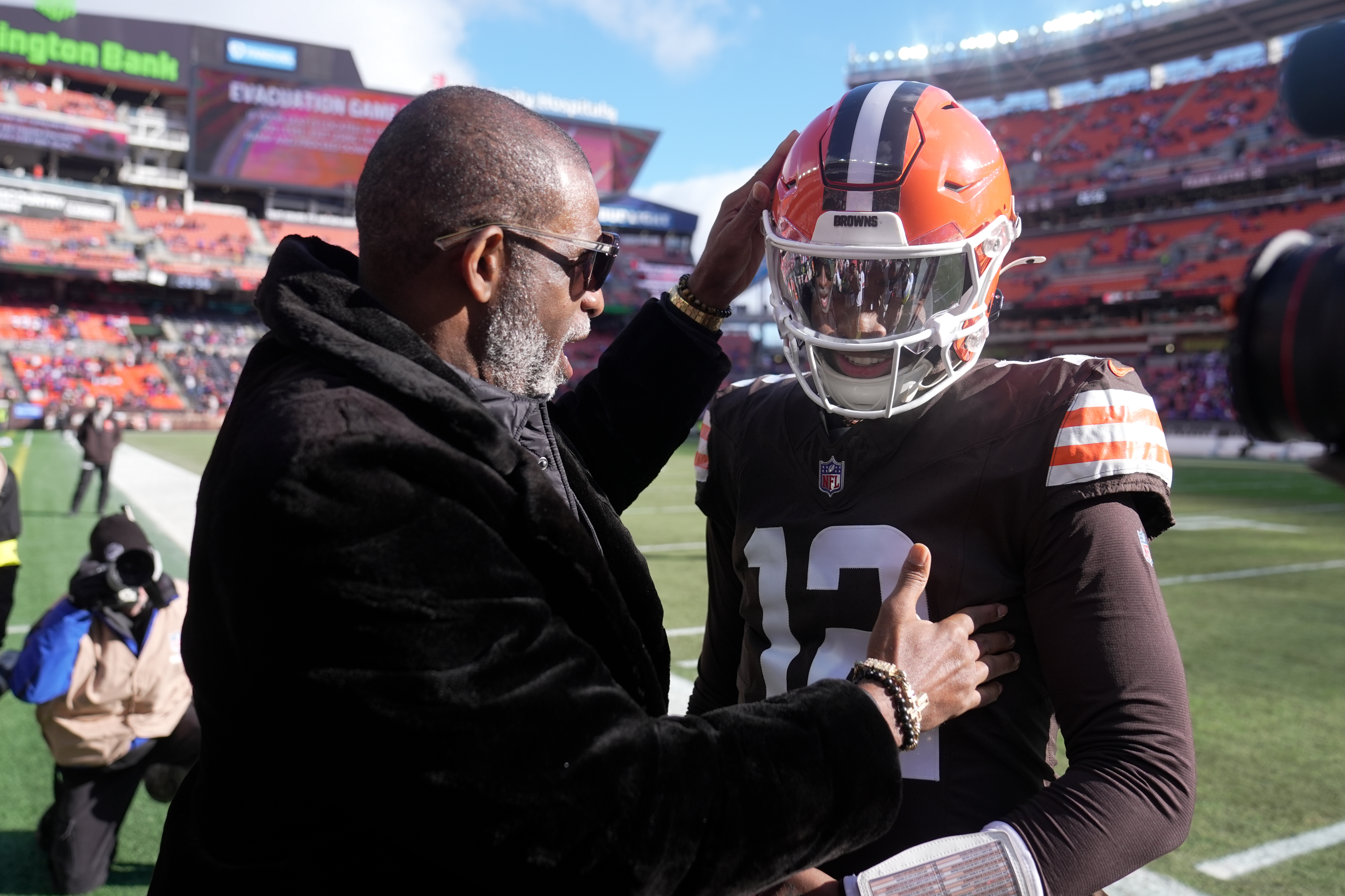 Cleveland Browns quarterback Shedeur Sanders greets his dad Deion Sanders prior to an NFL football game against the Buffalo Bills in Cleveland, Sunday, Dec. 21, 2025. (AP Photo/Sue Ogrocki)