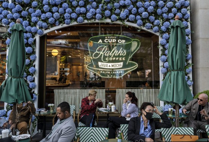 More retailers are opening coffee shops to appeal to customers who may not want to spend the big bucks—but still want a cup of joe