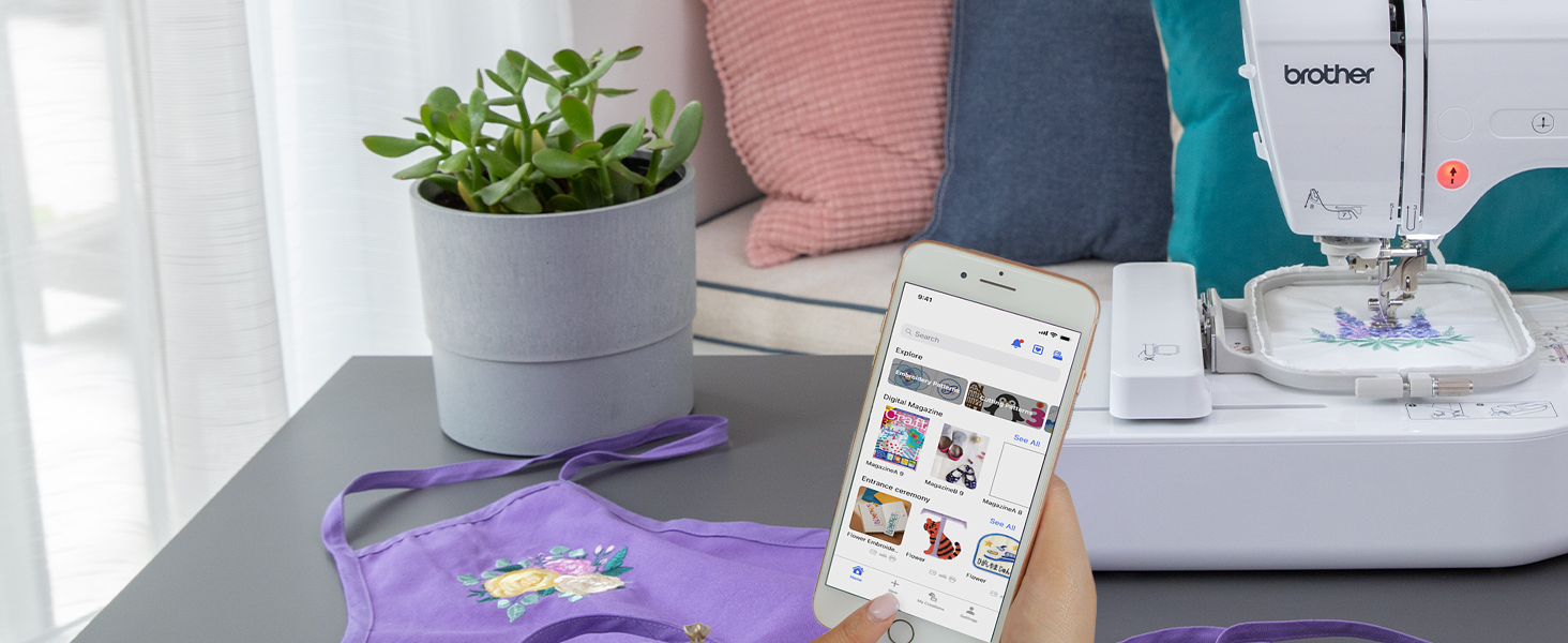 Person browsing designs in Artspira app on smartphone to use on PE545 embroidery machine