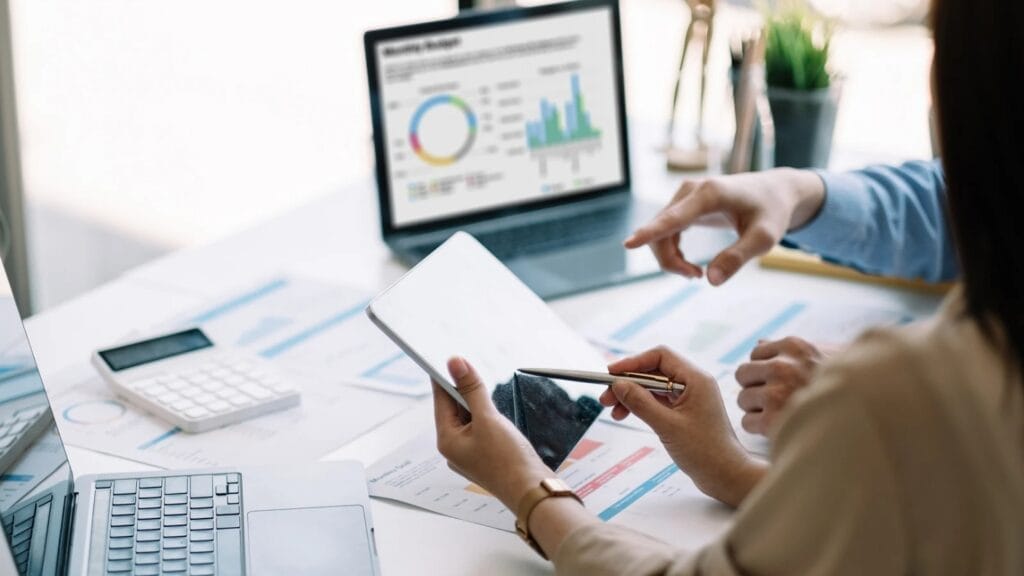 Workers looking at Google Analytics | Easy Affiliate Two people analysing affiliate marketing data with Google Analytics