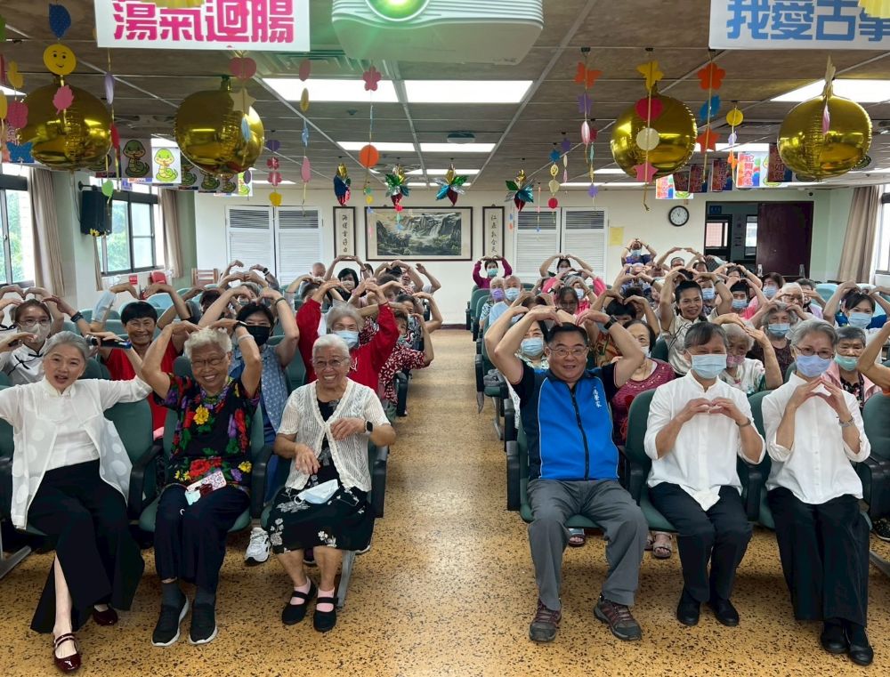 慈濟古箏班獻藝 八德榮家懷舊琴音豐富多元化文康 1 《圖說》八德榮家副主任程釋鋒(前排右3)與慈濟八德古箏班攜手比劃滿滿愛心。〈八德榮家提供〉