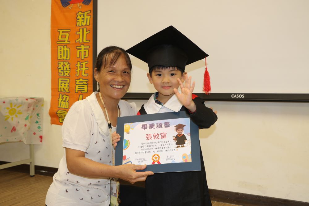 謝謝你陪我長大 新北居家托育互助協會聯合畢典溫馨感人 2 《圖說》居家托育人員為所照顧的孩子戴上方帽並致贈畢業證書。〈社會局提供〉