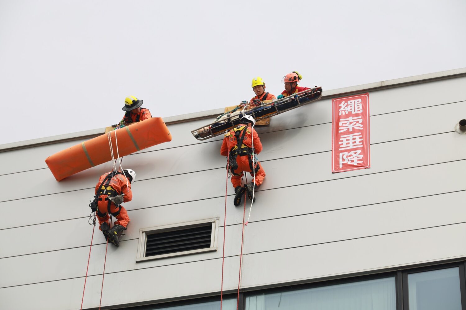 結合「科技救災與電動車火災」情境 新竹縣消防局強化工廠防災韌性 消防人員實施高空繩索垂降救援演練,模擬高樓受困人員救助情境,展現專業繩索技術與垂直救災能力,提升複合型災害應變效能。(圖/記者張家燁翻攝)