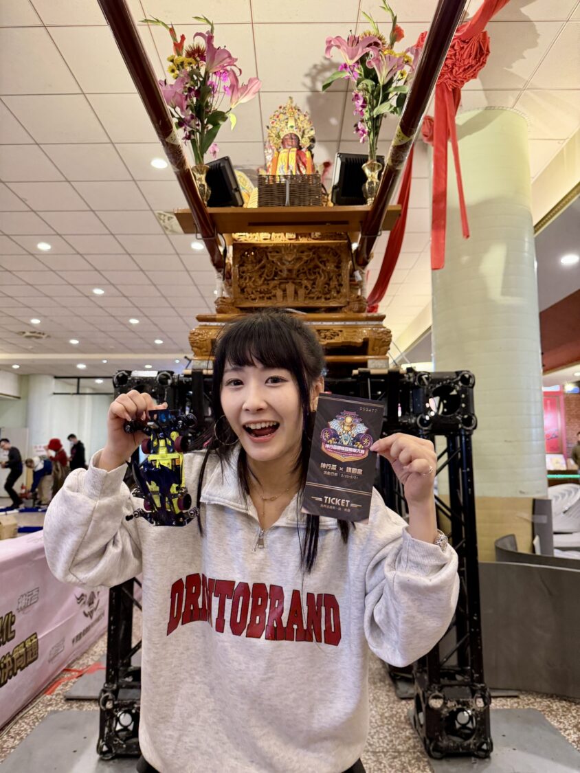 草爺、柯大堡 發起第一屆「神行盃國際四驅車大賽」首創「四驅車+ 鑽轎底」讓新年好運加速 上萬人齊聚桃園護國宮來祈福尬車 「電玩女神」陸子玄也體驗首創「四驅車鑽轎底」感受祈福神明加持。(圖/紅心字會 提供)