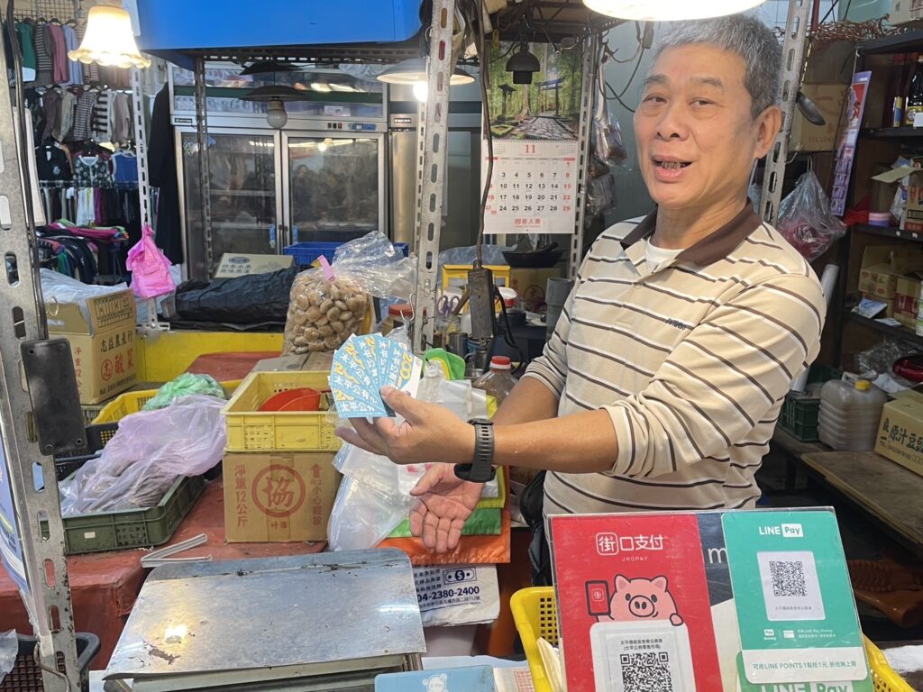台中物調券第二天買氣翻倍!市場、夜市、商圈人潮暴增 攤商歡喜收取物調券。(圖/台中市政府經濟發展局提供)