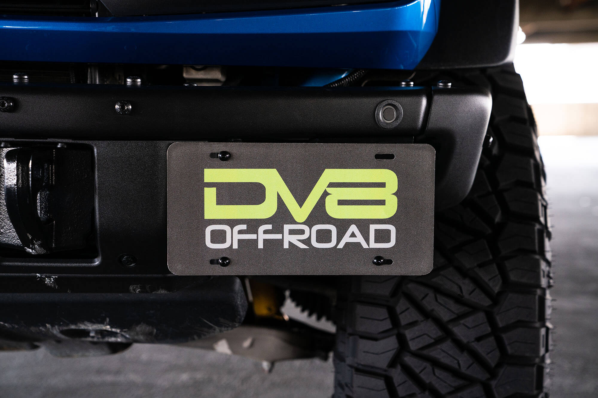 DV8 Offroad Front license plate relocation bracket places plate to the side of the bumper. LPBR-02