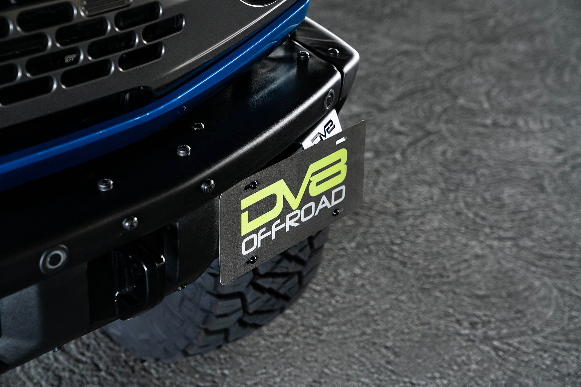 DV8 Offroad Front license plate relocation bracket places plate to the side of the bumper. LPBR-02