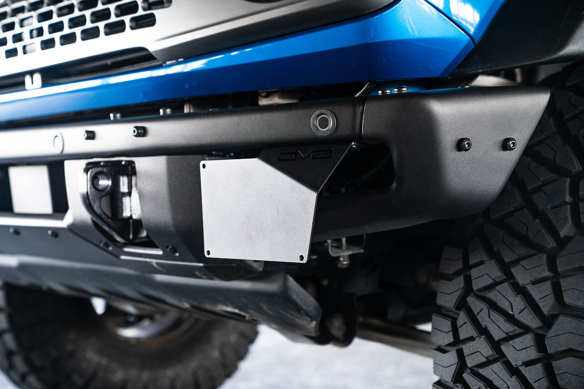 DV8 Offroad Front license plate relocation bracket places plate to the side of the bumper. LPBR-02