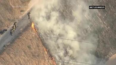 Fire crews extinguish a brush fire along Interstate 405 near Los Angeles Fire crews extinguish a brush fire along Interstate 405 near Los Angeles