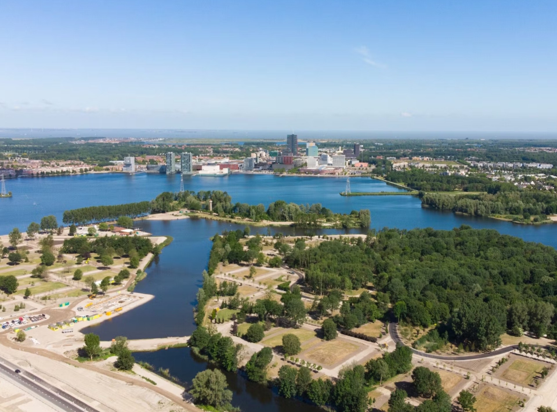 A panoramic view of Almere showcasing modern architecture and green spaces under a clear blue sky. A panoramic view of Almere showcasing modern architecture and green spaces under a clear blue sky.