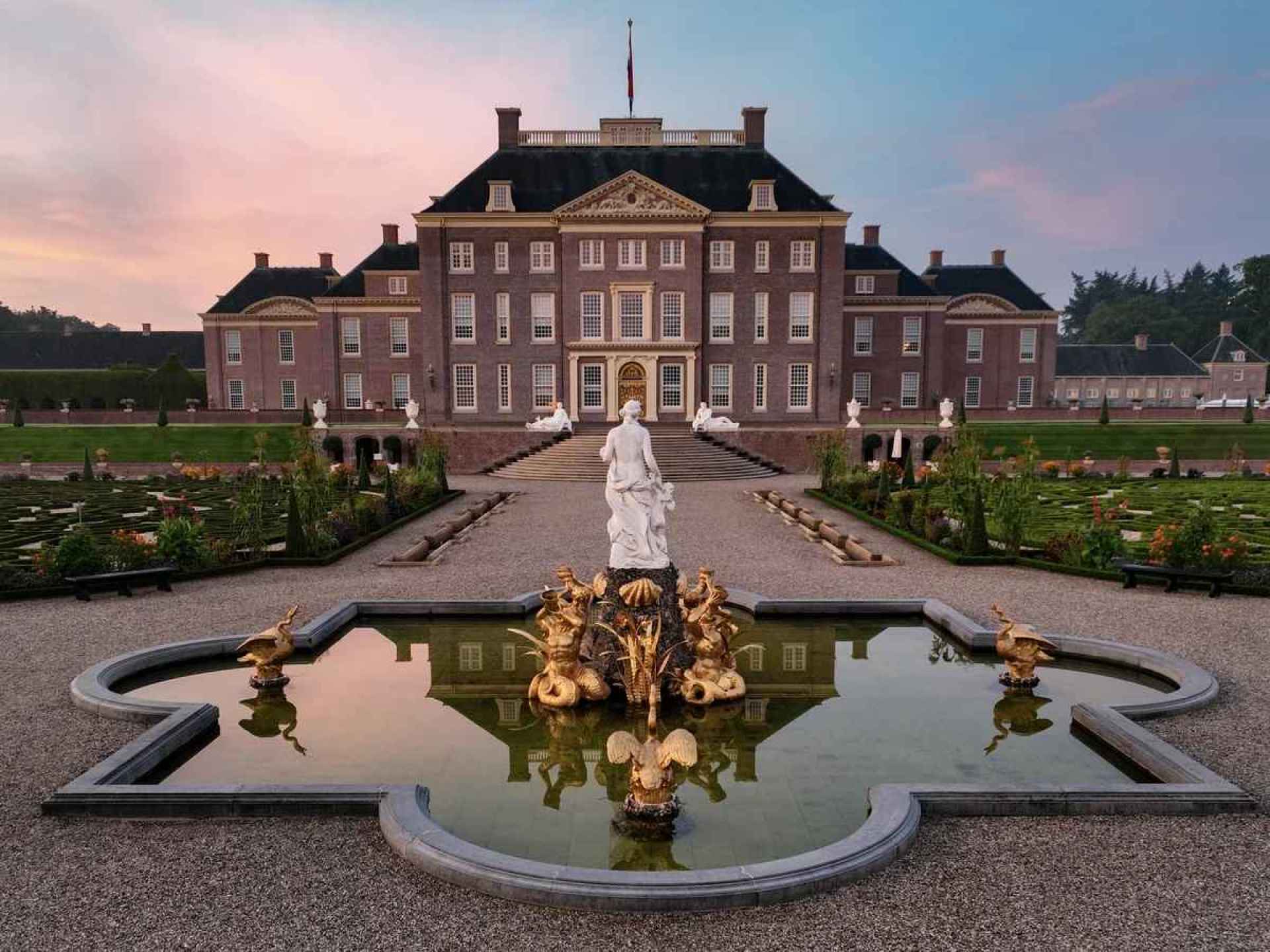 A beautiful view of Het Loo Palace in Apeldoorn, showcasing its stunning architecture and well-maintained gardens. A beautiful view of Het Loo Palace in Apeldoorn, showcasing its stunning architecture and well-maintained gardens.