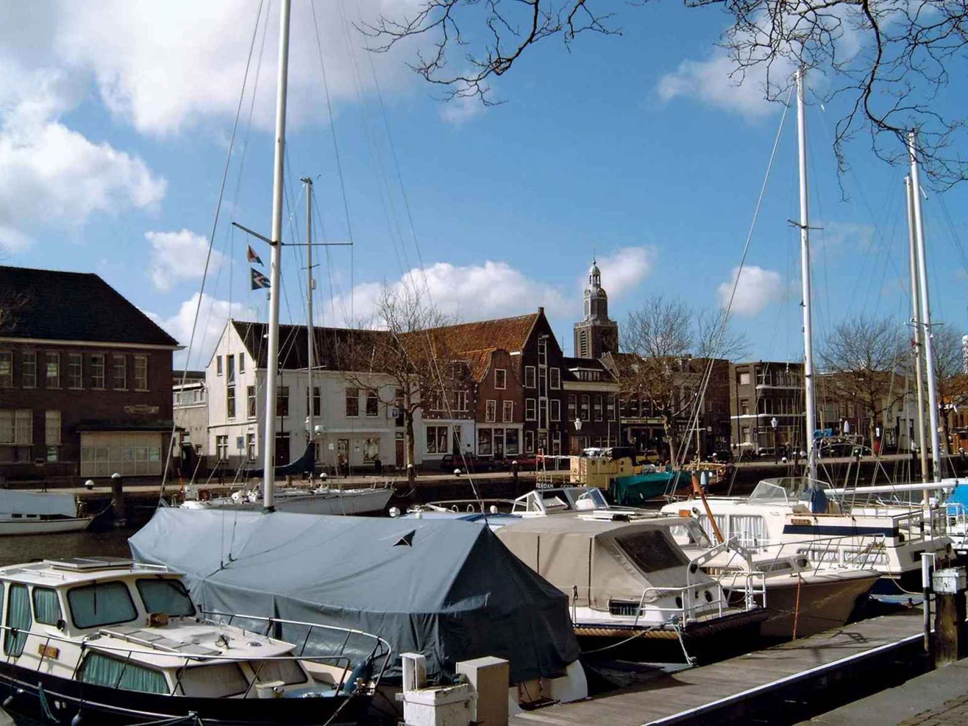 Vlaardingen's harbor showcasing boats and waterfront activity in a picturesque setting by the water. Vlaardingen's harbor showcasing boats and waterfront activity in a picturesque setting by the water.