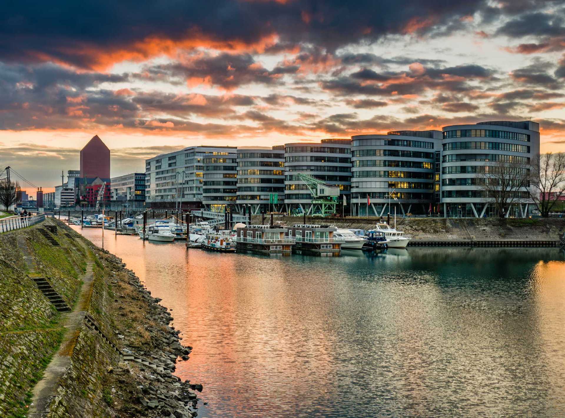 A scenic view of the Duisburg Inner Harbour showcasing modern architecture and waterfront activities in Germany. A scenic view of the Duisburg Inner Harbour showcasing modern architecture and waterfront activities in Germany.