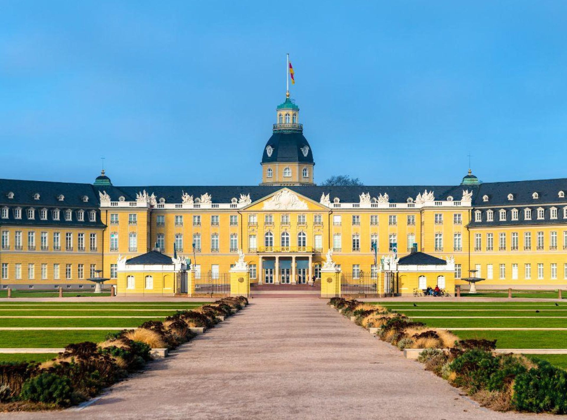 A majestic view of Karlsruhe Palace showcasing its stunning architecture and gardens in the heart of Karlsruhe, Germany. A majestic view of Karlsruhe Palace showcasing its stunning architecture and gardens in the heart of Karlsruhe, Germany.