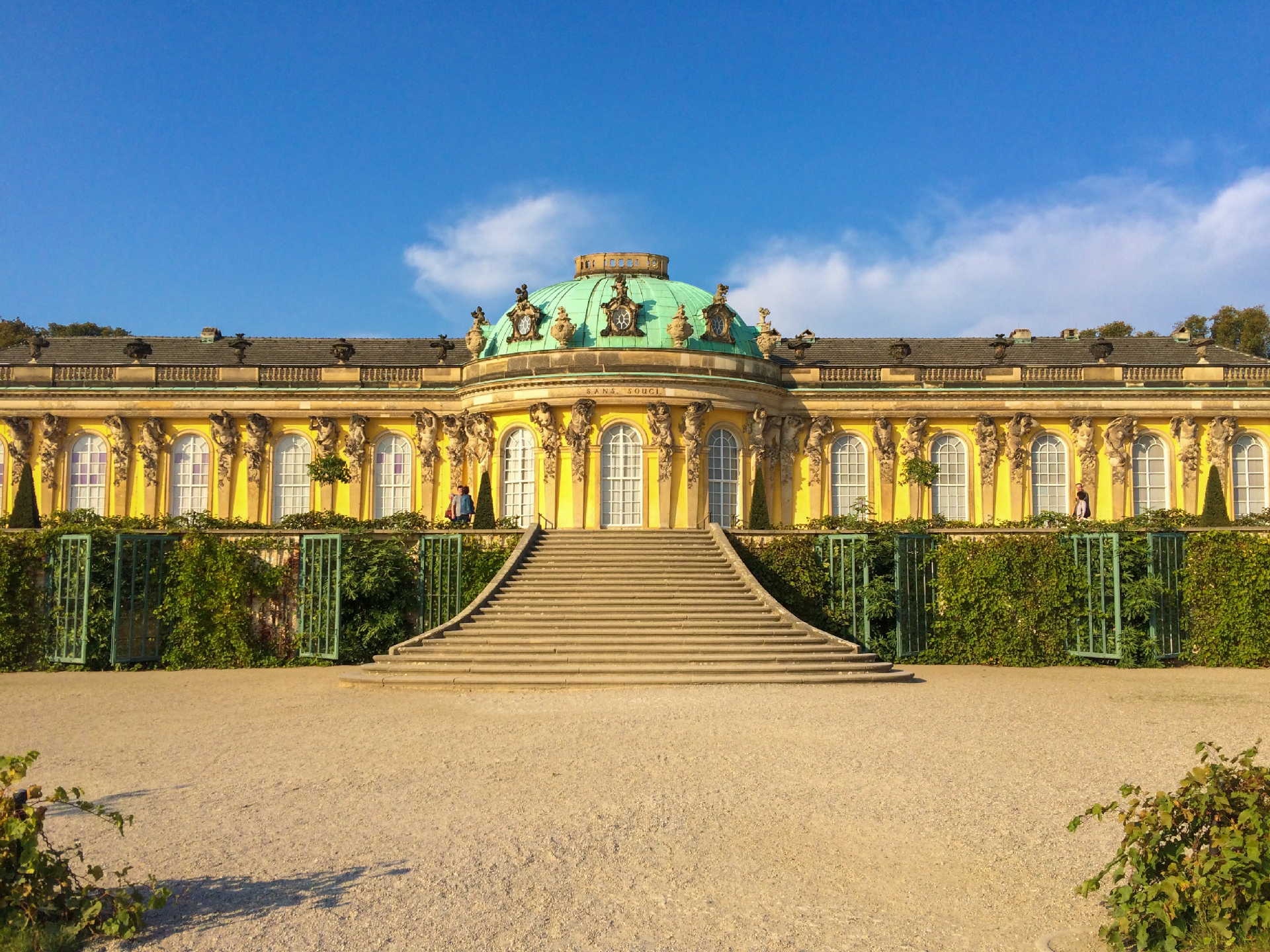 A stunning view of the Sanssouci Palace in Potsdam, showcasing its beautiful architecture and lush gardens. A stunning view of the Sanssouci Palace in Potsdam, showcasing its beautiful architecture and lush gardens.