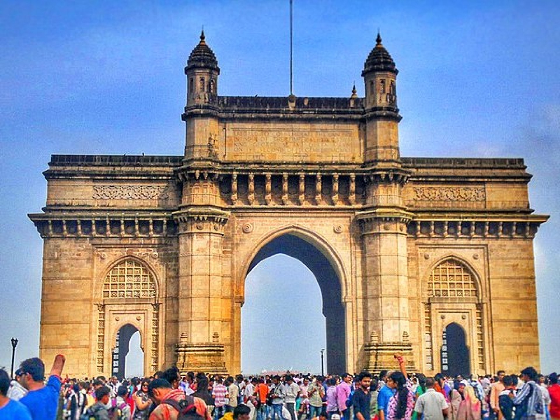 Iconic view of the Gateway of India in Mumbai with tourists enjoying the scenic waterfront and historic architecture. Iconic view of the Gateway of India in Mumbai with tourists enjoying the scenic waterfront and historic architecture.