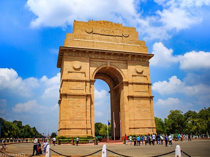 A panoramic view of India Gate in Delhi, showcasing the iconic monument surrounded by greenery and vibrant city life. A panoramic view of India Gate in Delhi, showcasing the iconic monument surrounded by greenery and vibrant city life.