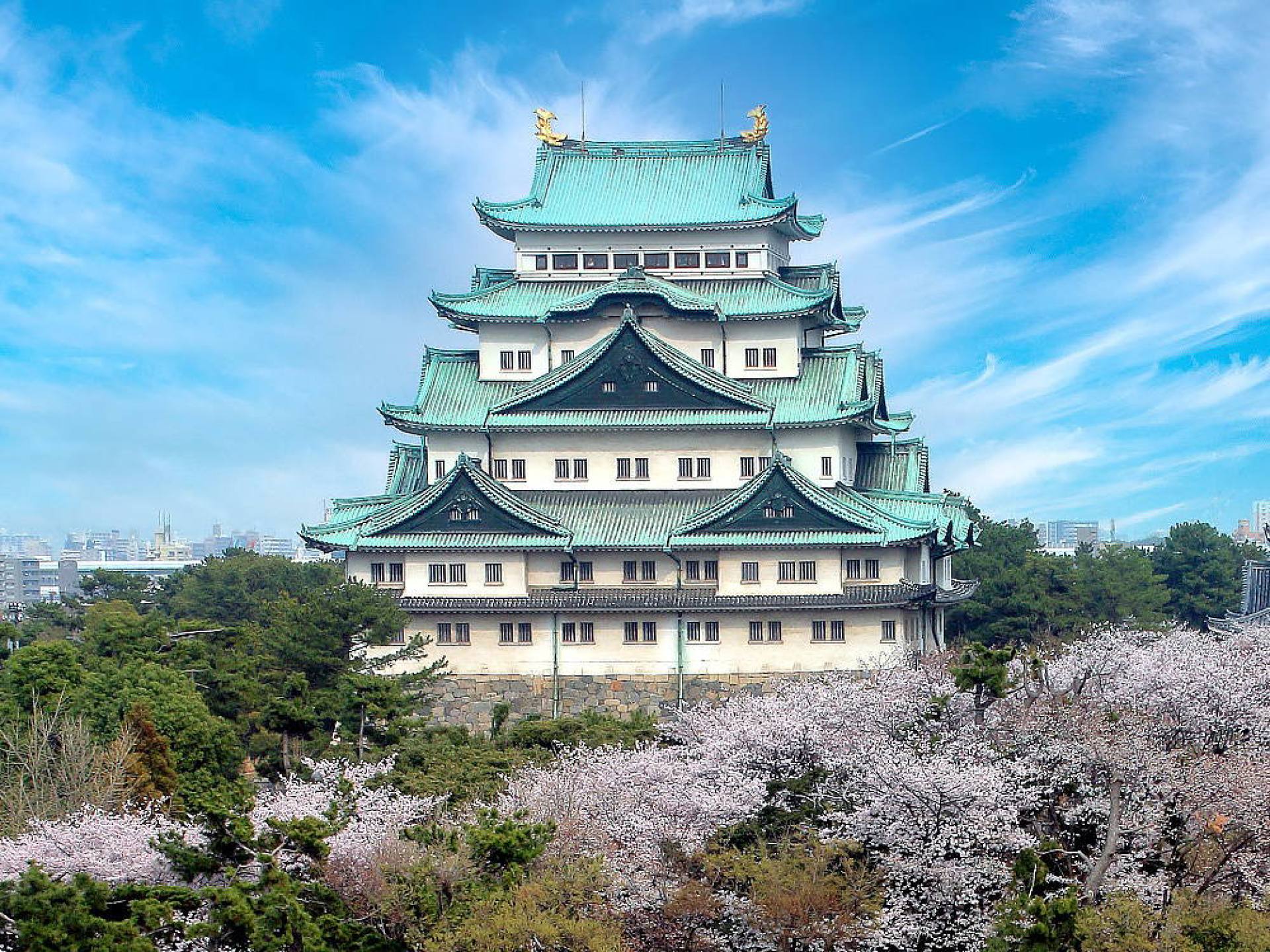 A view of Nagoya Castle showcasing its distinctive green roofs and historic architecture set against a clear blue sky. A view of Nagoya Castle showcasing its distinctive green roofs and historic architecture set against a clear blue sky.