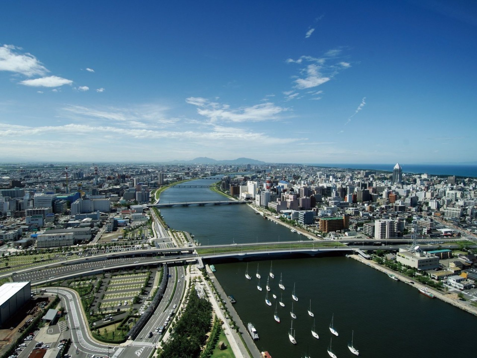 A scenic view of Niigata City, showcasing its beautiful architecture and vibrant atmosphere against a clear blue sky. A scenic view of Niigata City, showcasing its beautiful architecture and vibrant atmosphere against a clear blue sky.