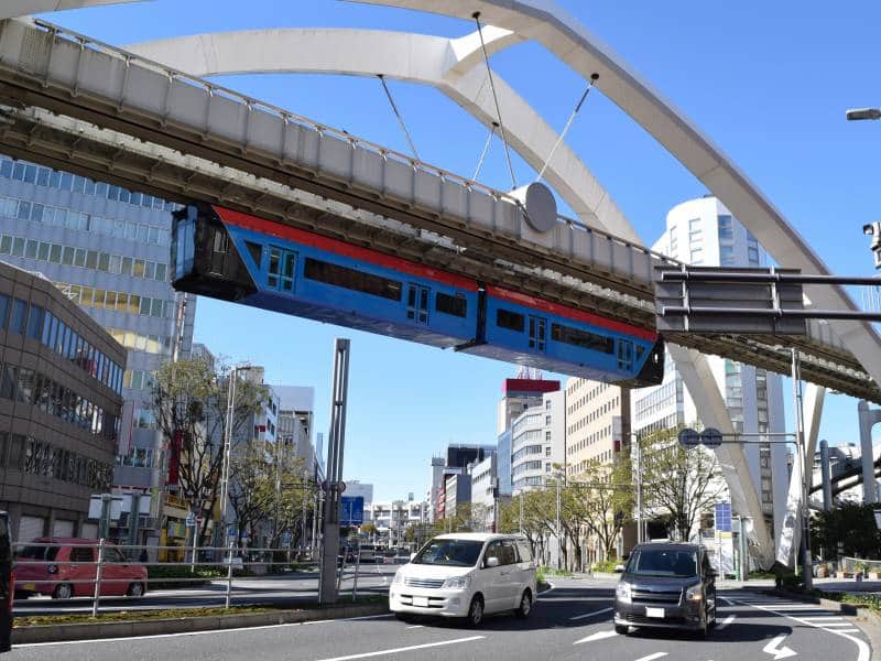A Chiba monorail train glides above vibrant city streets, showcasing the urban landscape and efficient public transport system. A Chiba monorail train glides above vibrant city streets, showcasing the urban landscape and efficient public transport system.