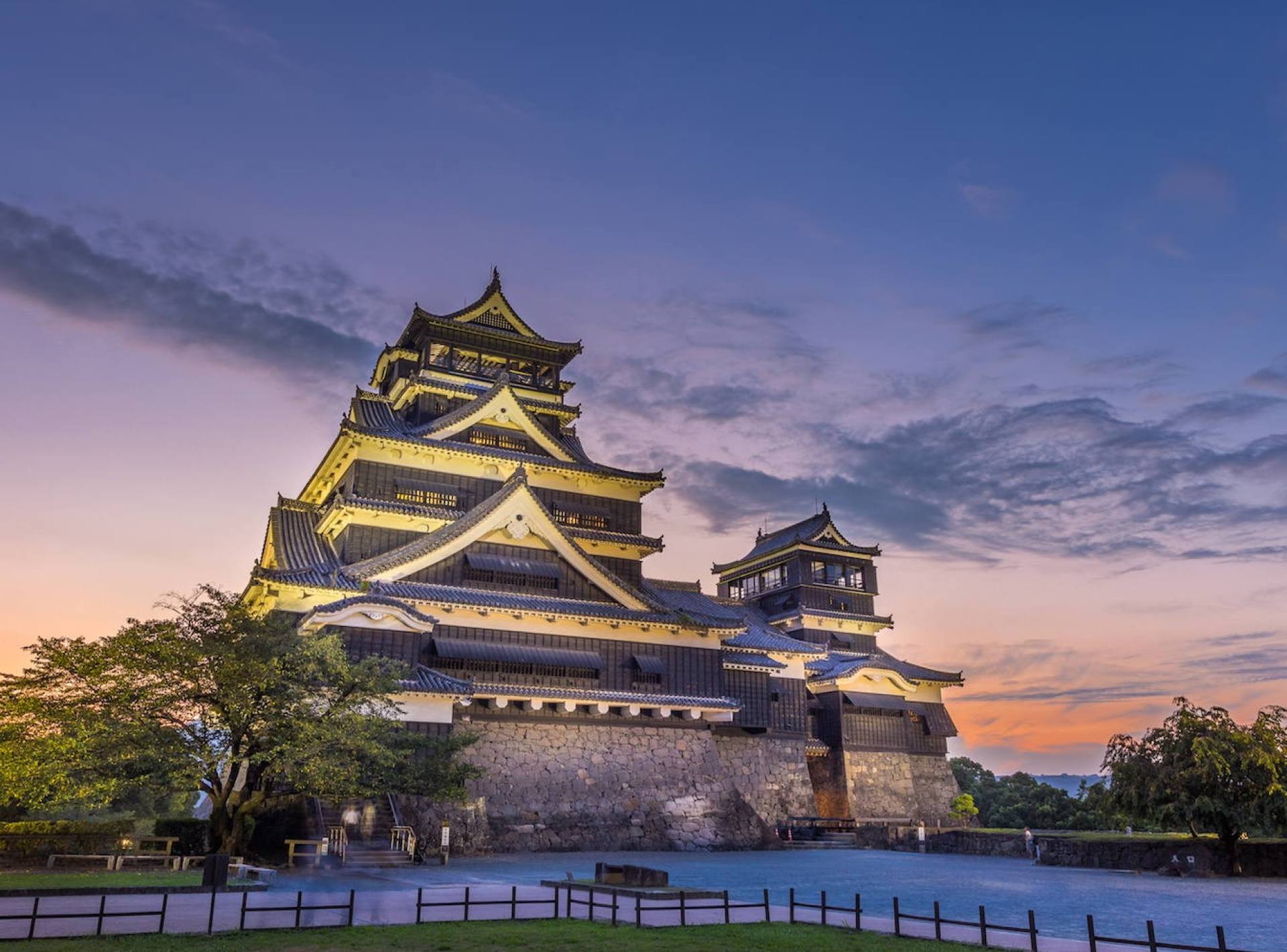 A scenic view of Kumamoto Castle showcasing its historic architecture and surrounding greenery. A scenic view of Kumamoto Castle showcasing its historic architecture and surrounding greenery.