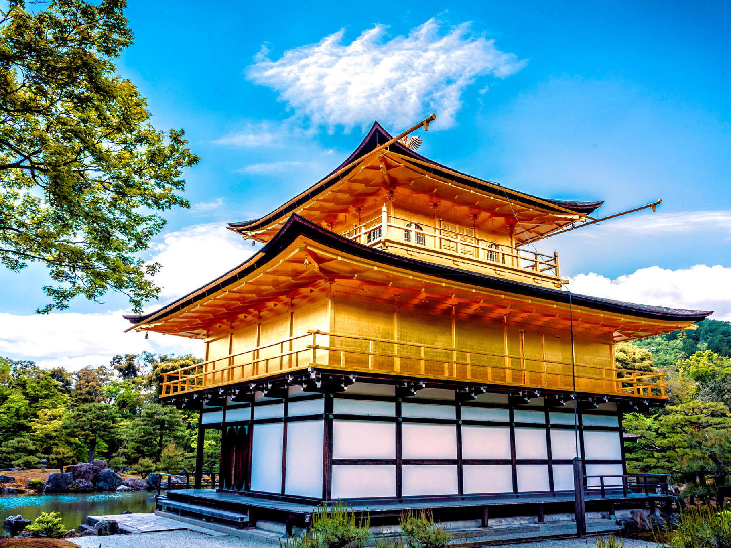 Serene view of Kinkaku-ji Temple surrounded by lush greenery in Kyoto, showcasing its iconic golden architecture reflected in the tranquil pond. Serene view of Kinkaku-ji Temple surrounded by lush greenery in Kyoto, showcasing its iconic golden architecture reflected in the tranquil pond.
