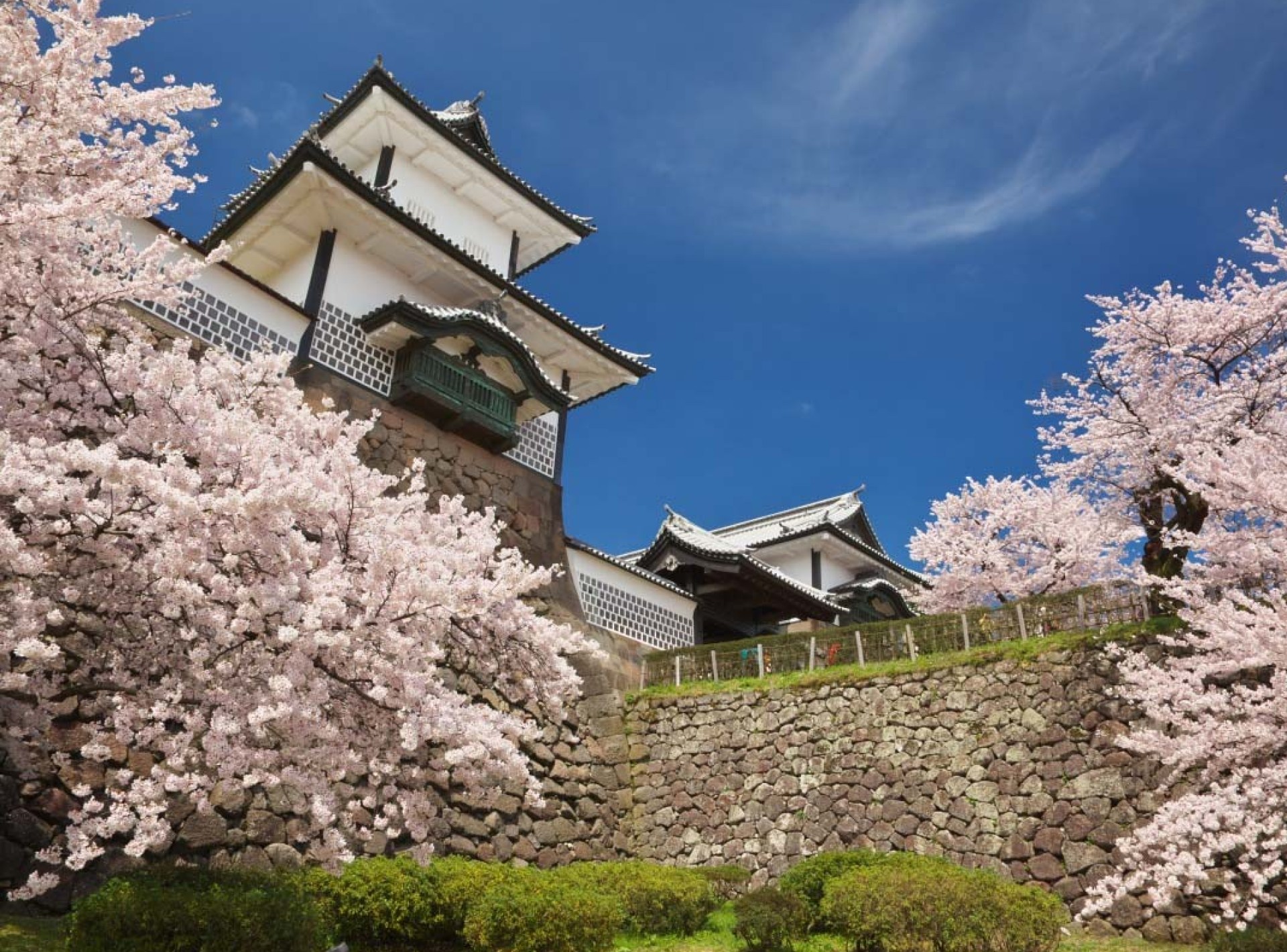 A scenic view of Kanazawa Castle surrounded by lush greenery and a clear blue sky, showcasing its historical architecture. A scenic view of Kanazawa Castle surrounded by lush greenery and a clear blue sky, showcasing its historical architecture.