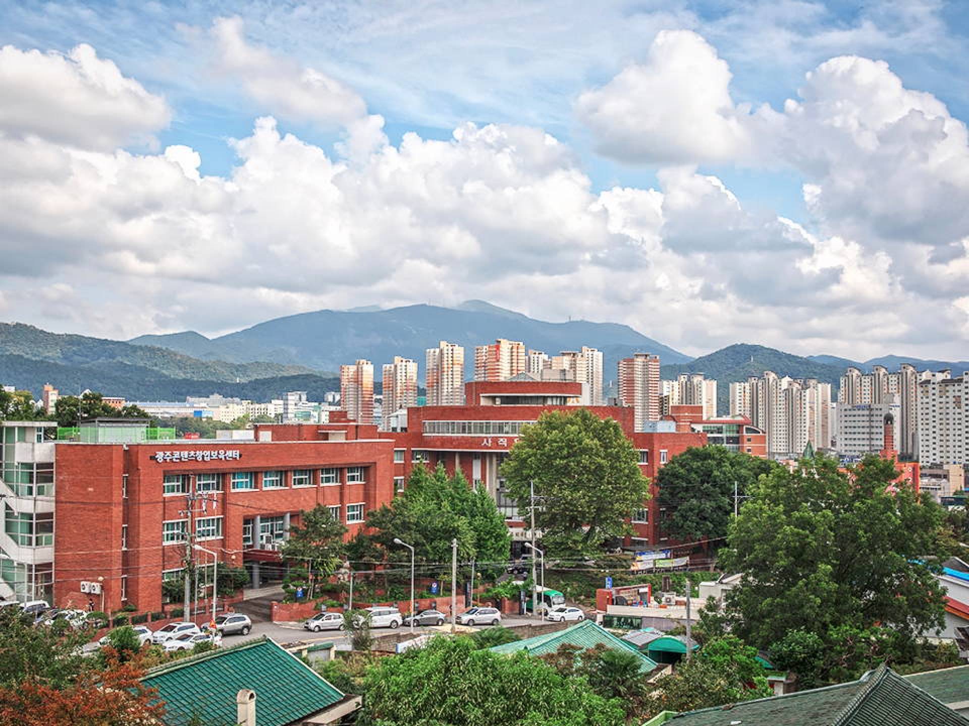 A panoramic view of Gwangju showcasing its modern skyline and green spaces under a clear blue sky. A panoramic view of Gwangju showcasing its modern skyline and green spaces under a clear blue sky.