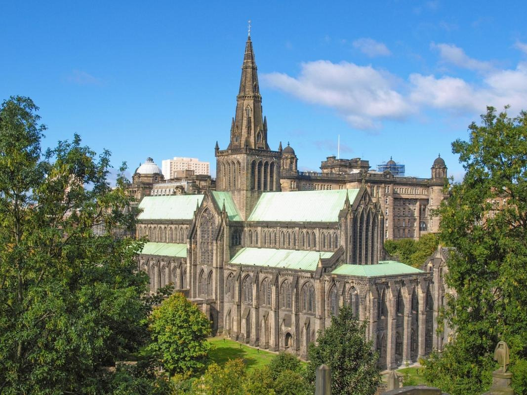 A stunning view of Glasgow Cathedral showcasing its Gothic architecture against a clear blue sky. A stunning view of Glasgow Cathedral showcasing its Gothic architecture against a clear blue sky.