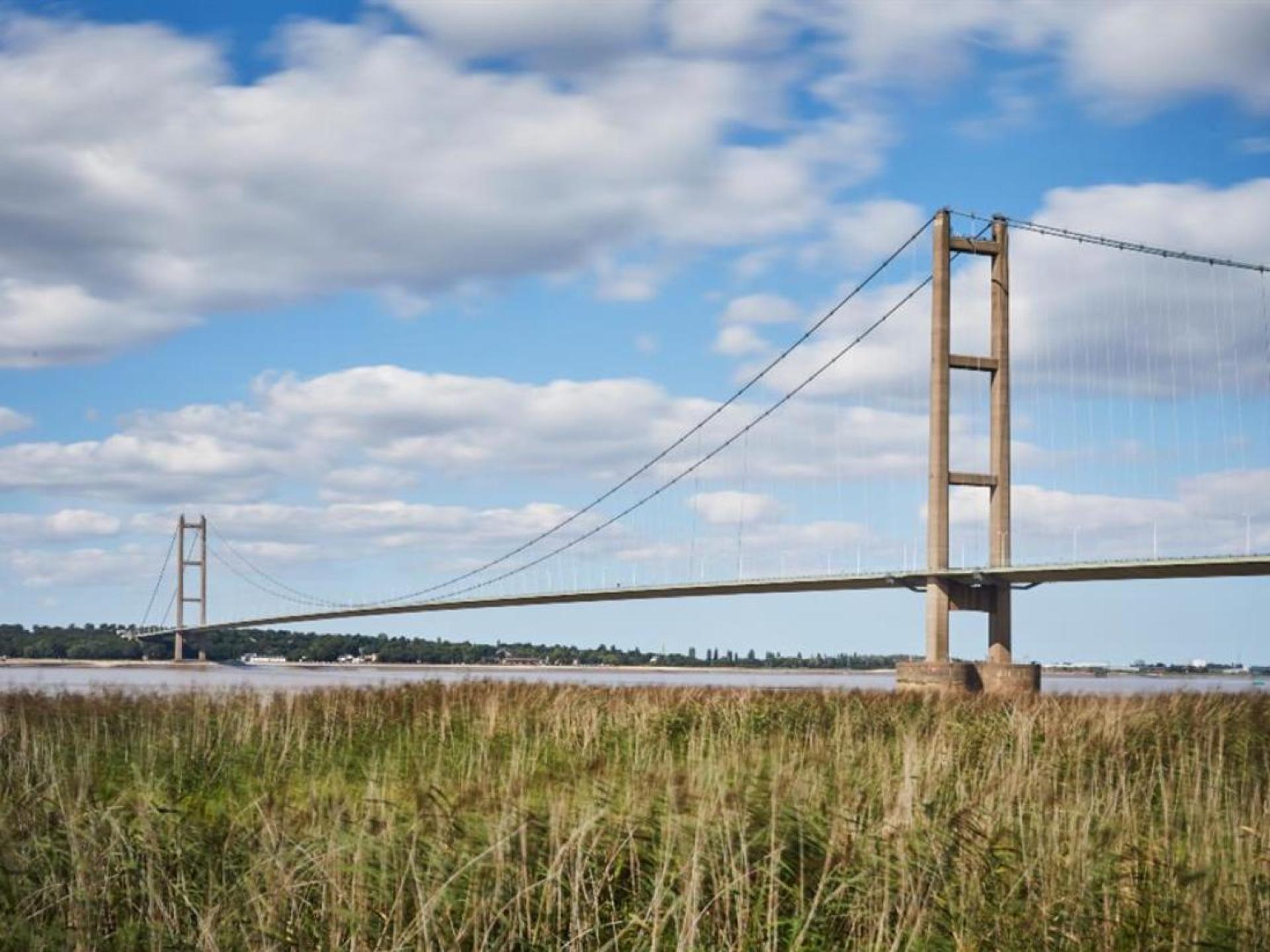 The Humber Bridge spans across the water in Hull, UK, showcasing its impressive architecture against a scenic backdrop. The Humber Bridge spans across the water in Hull, UK, showcasing its impressive architecture against a scenic backdrop.