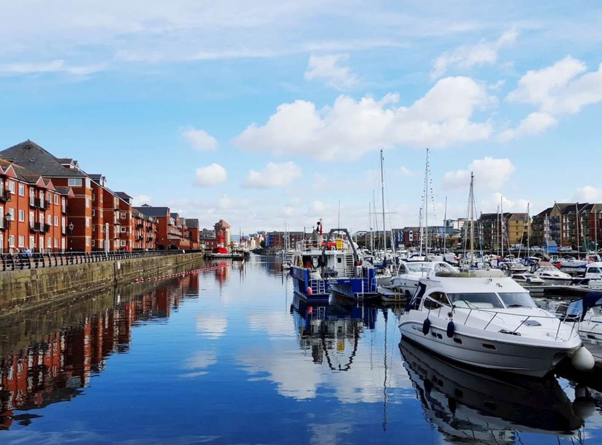 A scenic view of Swansea Marina showcasing boats and waterfront activity in a vibrant coastal setting. A scenic view of Swansea Marina showcasing boats and waterfront activity in a vibrant coastal setting.