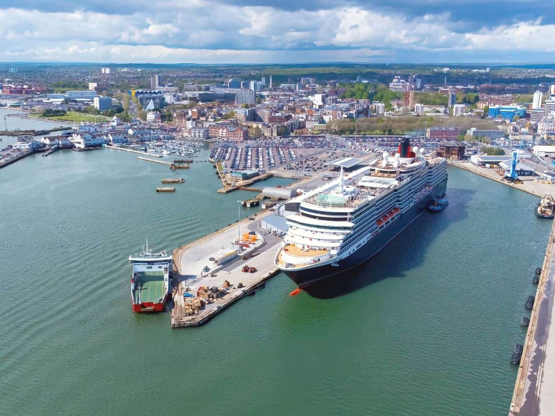 A busy view of Southampton docks featuring container ships and bustling activity along the waterfront. A busy view of Southampton docks featuring container ships and bustling activity along the waterfront.