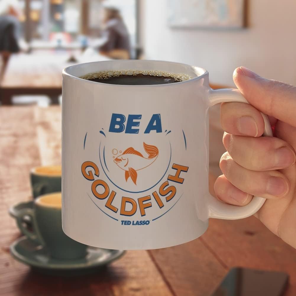 GRAPHICS & MORE Ted Lasso Be A Goldfish – Taza de café de cerámica, novedosa taza de regalo para café, té y bebidas calientes, 11 onzas, color blanco