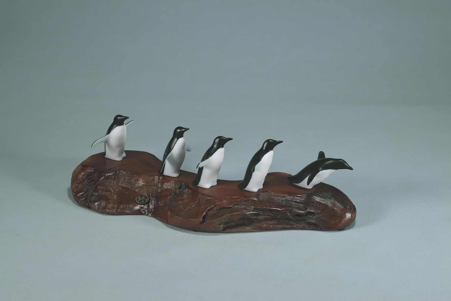 Penguin flock of 5 sculpture by John Perry approx 11 inches long on burl base