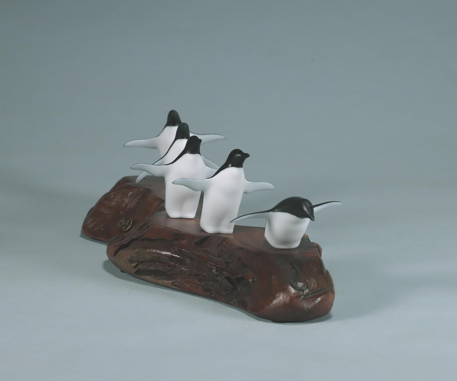 Penguin flock of 5 sculpture by John Perry approx 11 inches long on burl base