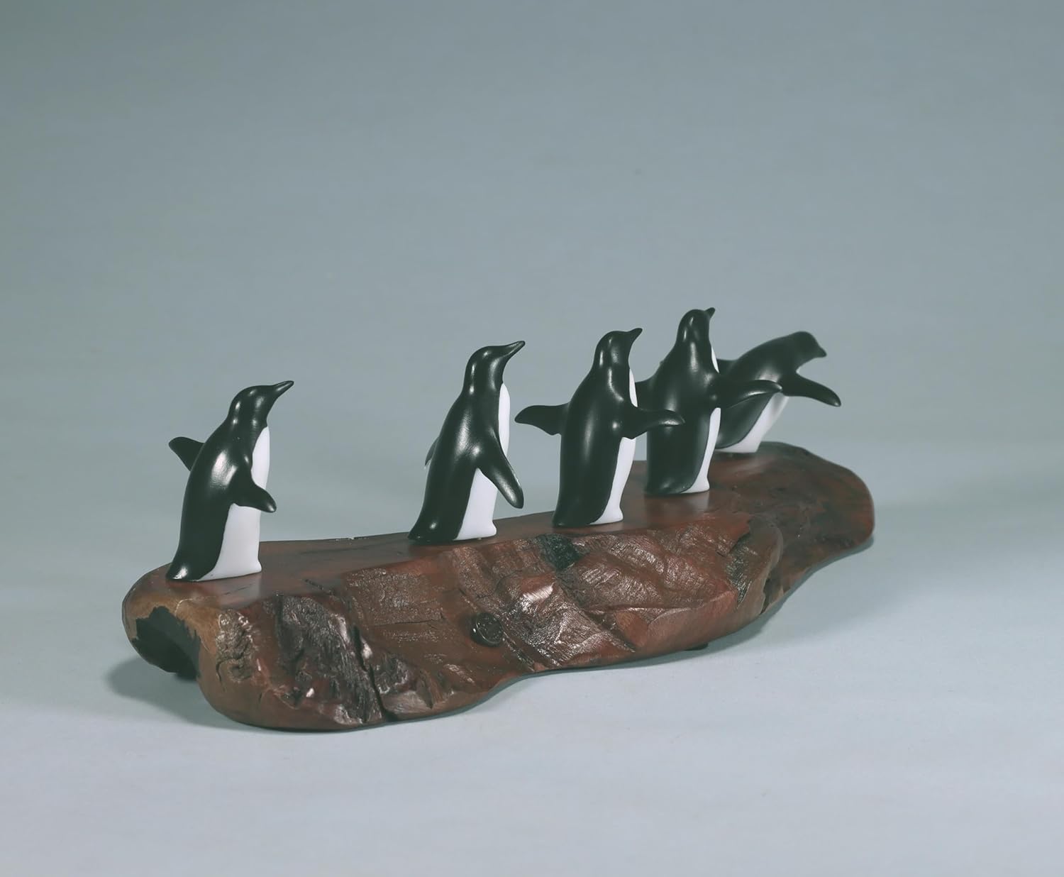 Penguin flock of 5 sculpture by John Perry approx 11 inches long on burl base