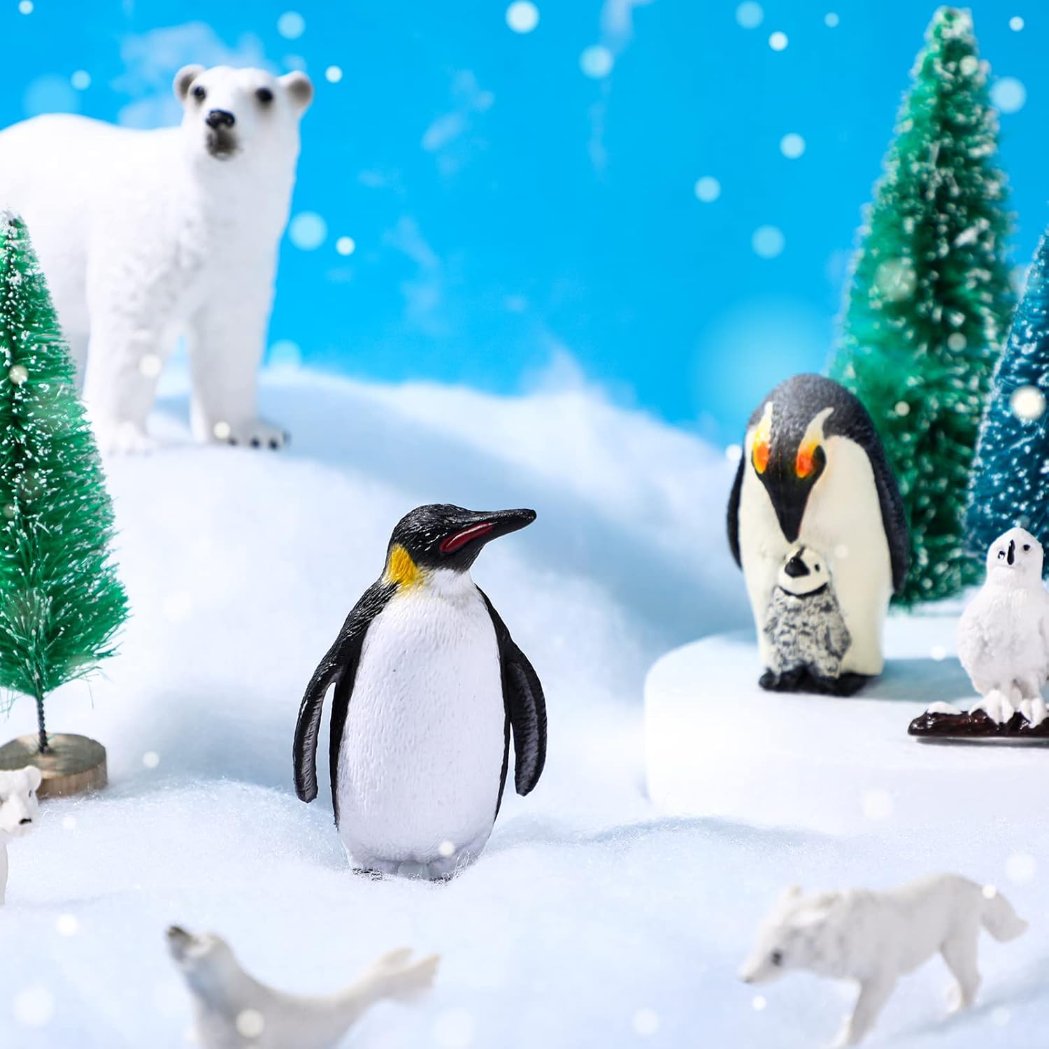 El juego de 19 juguetes de animales árticos incluye 10 figuras de animales polares, 6 pinos en miniatura, 1 tabla de espuma, 1 manta de nieve falsa