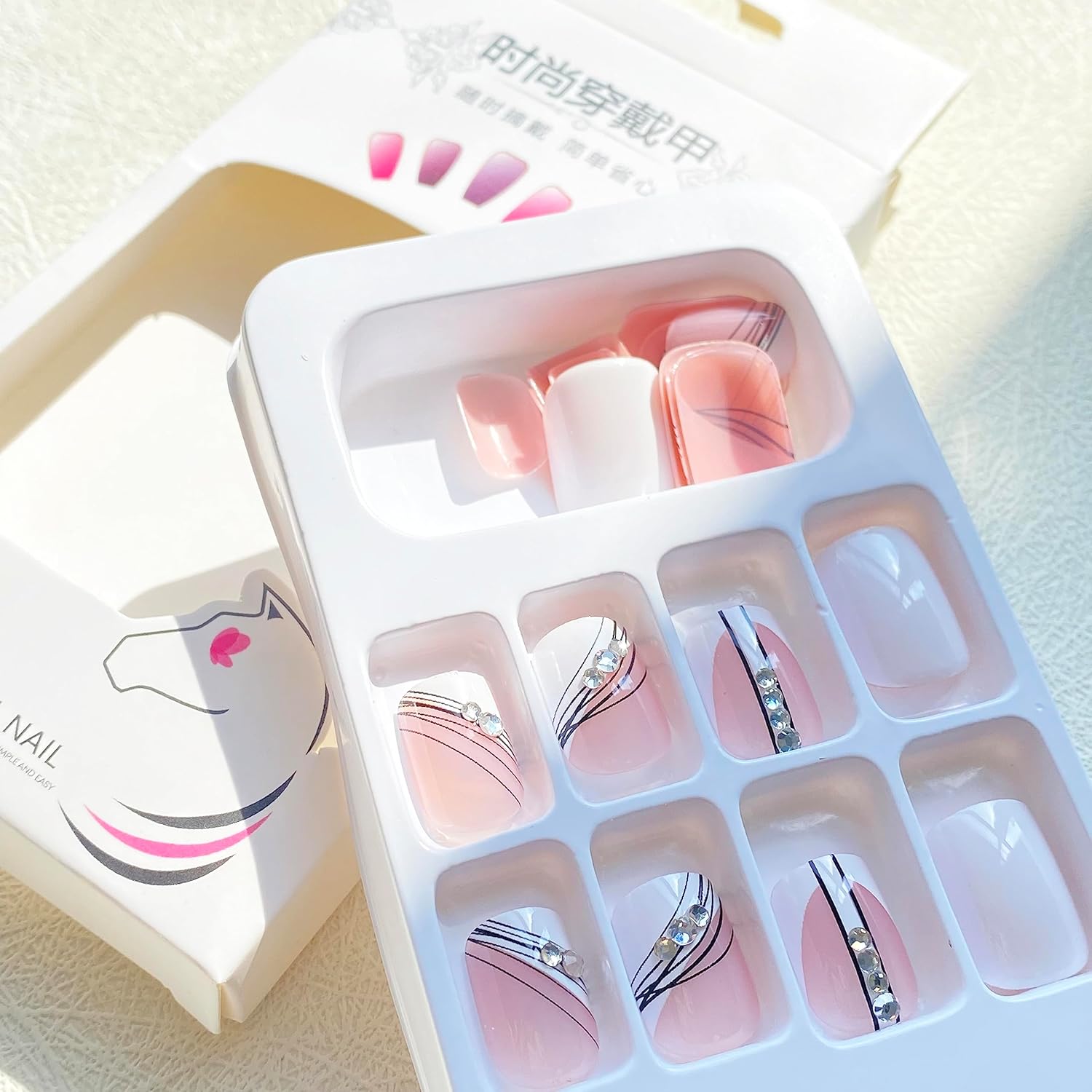 Uñas postizas a presión de punta francesa medianas con diseños de líneas negras, uñas adhesivas con diamantes de imitación blanco nude crema con