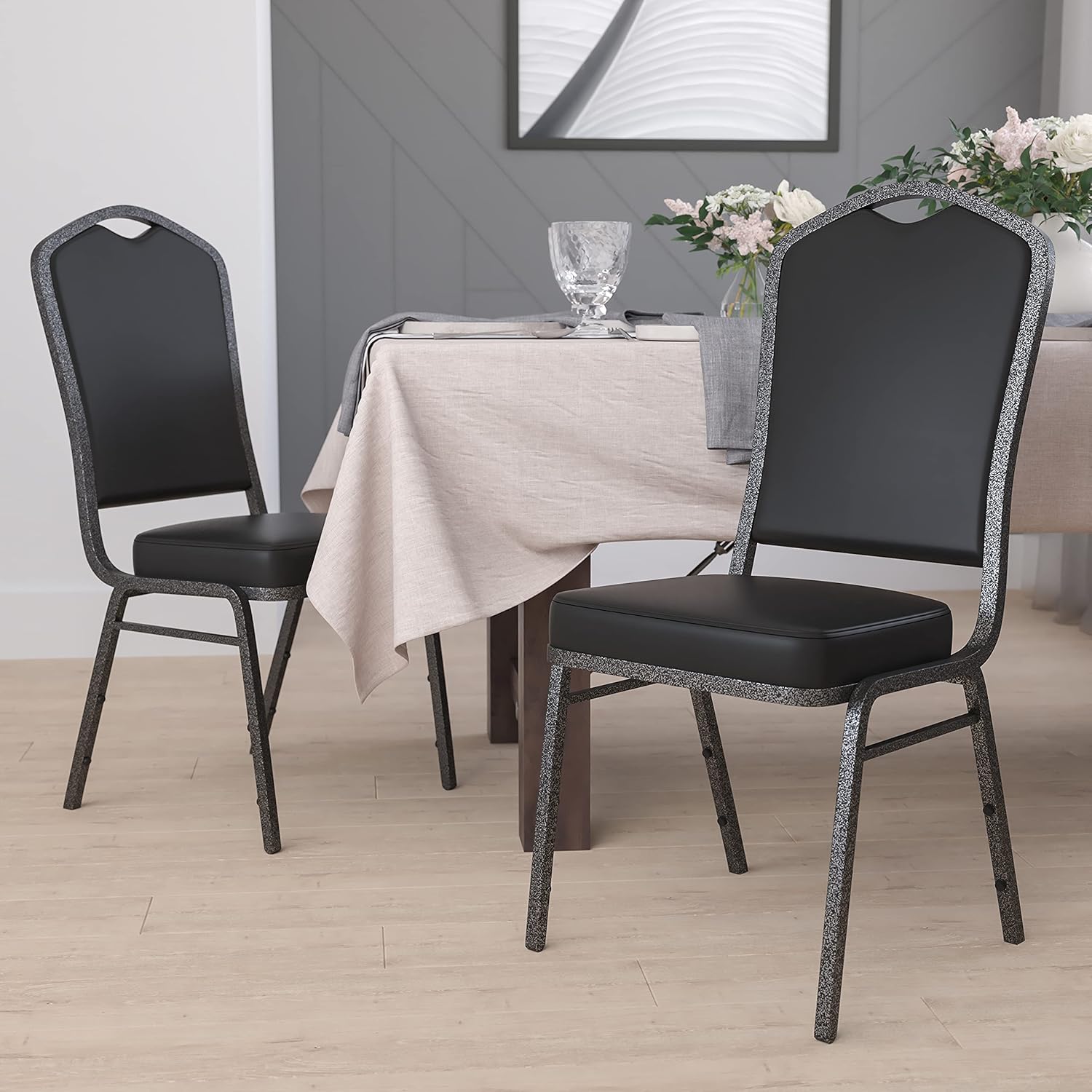 BizChair Paquete de 4 sillas apilables para banquetes con respaldo de corona en vinilo negro, marco de vena plateada