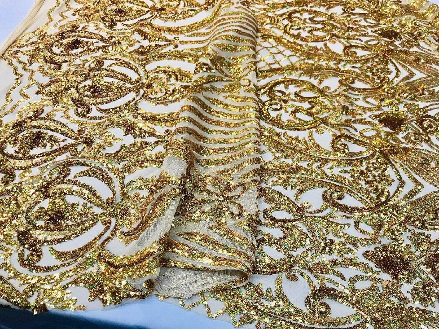 Diseño de lentejuelas de damasco iridiscente dorado en una malla elástica de 4 vías por yarda.